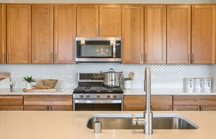 Light colored wood cabinetry, nickel bath fixtures and stainless steel appliances complete this Seni