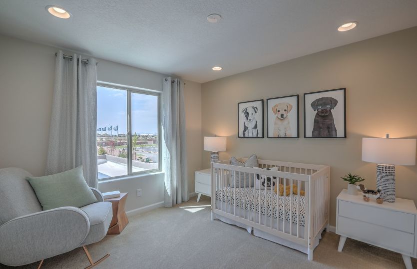 Bedroom 2 modeled as a nursery is light and bright with overhead recessed can lighting and an energy