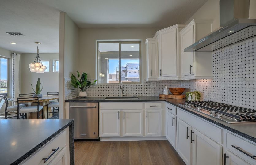 Stainless steel Kitchenaid® appliances including a gas cooktop, vent hood, built-in oven and dishwas