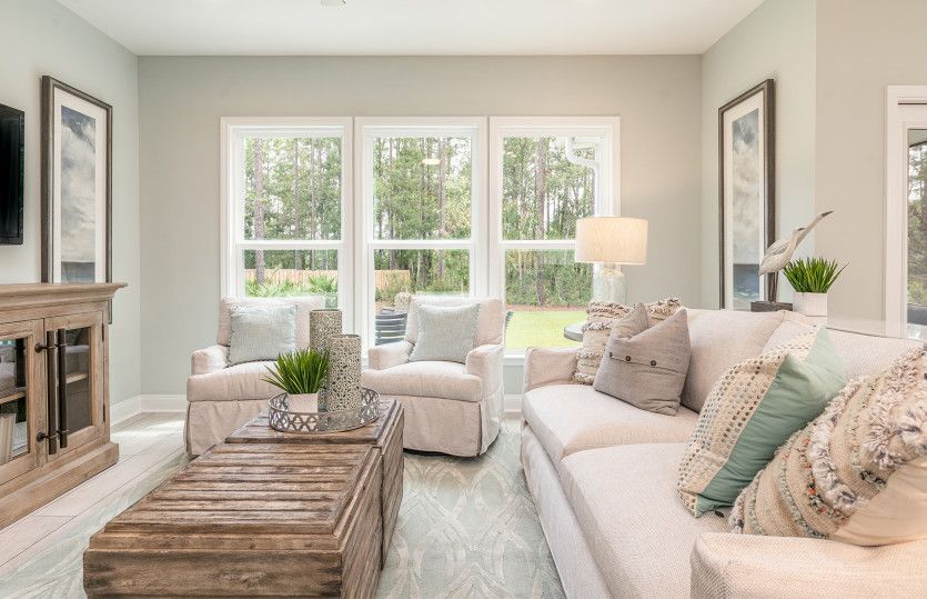 Gathering room boasts triple windows, tile flooring, and wall space for a flat screen TV.