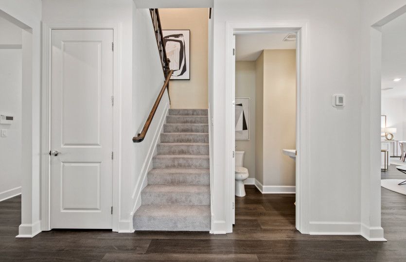 Stairway to loft with adjacent powder bath & storage