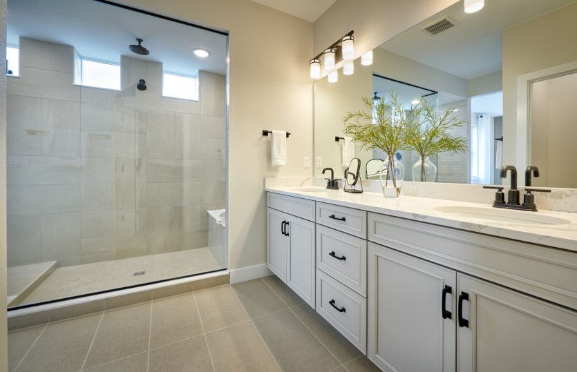 The private owner's bath features a dual sink vanity and a spacious walk-in shower.