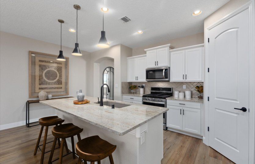 The Barlettta kitchen boasts functionality throughout with ample counter space, cabinetry, and a cor