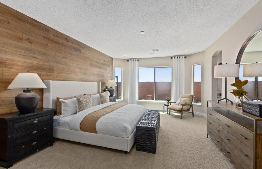 Enter the owner's suite featuring a wood accent wall and a stylish bay window upgrade.