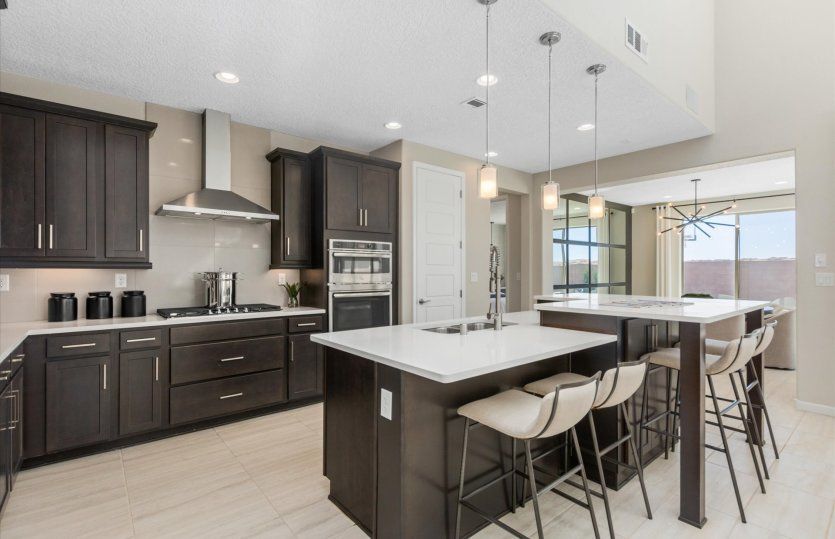 The luxurious Yucca kitchen shown with dark brown cabinetry and a large kitchen island.