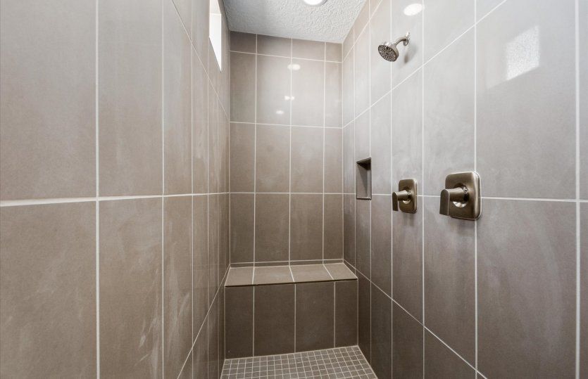 Unwind in the spacious, walk-in shower featuring tile accents.