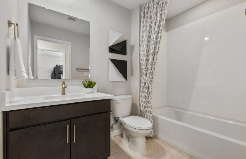 The secondary upstairs bath features a shower/tub combo.