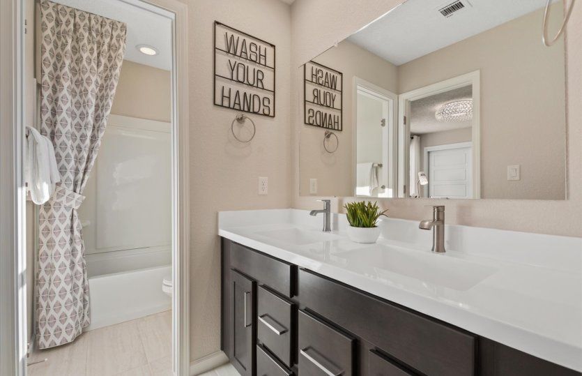 Jack & Jill bath shown with a shower/tub combo and dual sink vanity.