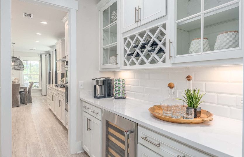 Optional Beverage Center with white cabinets, tile backsplash, wine refrigerator and wine storage ar