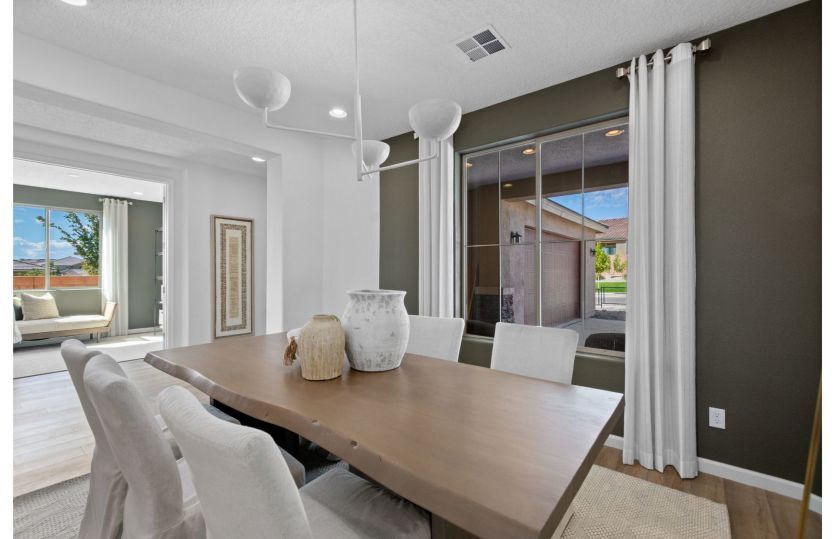 Formal dining room with an accent wall and beautiful modern chandelier.