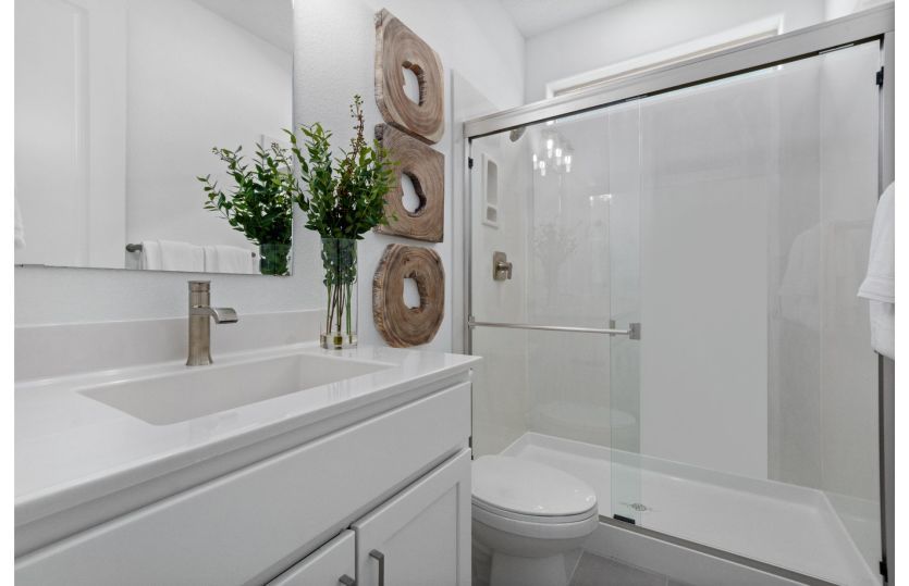 Guest suite bathroom includes a walk-in shower and modern white accents.