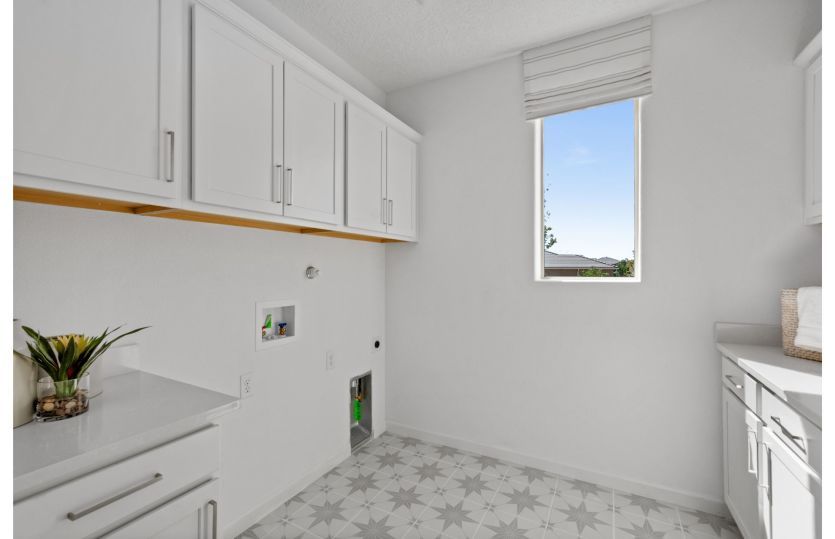 Laundry room with cabinets for additional storage space.