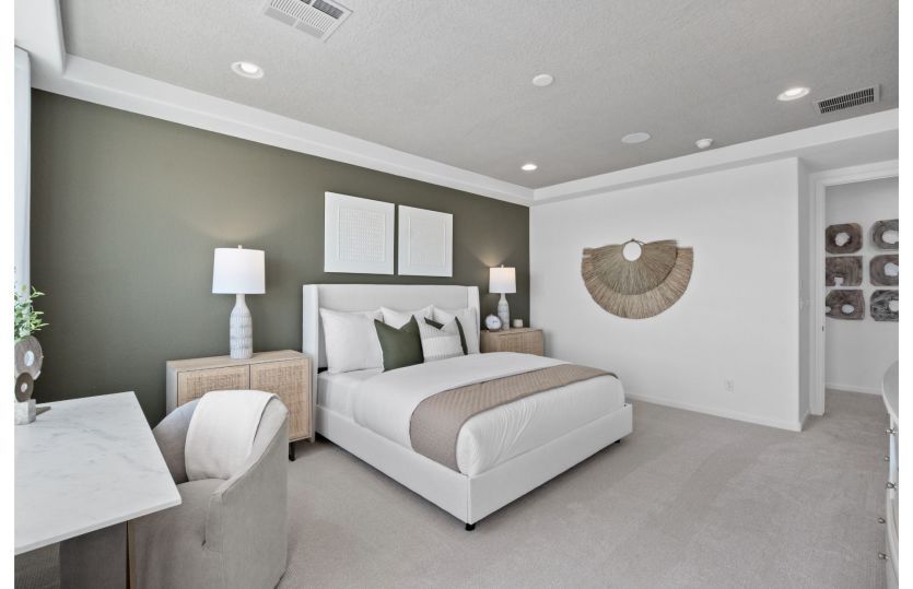 Owner's suite with accent wall and tray ceilings.