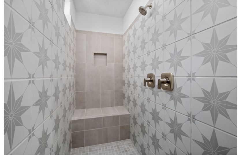 Large walk-in shower in owner's bath features beautiful accent tile.