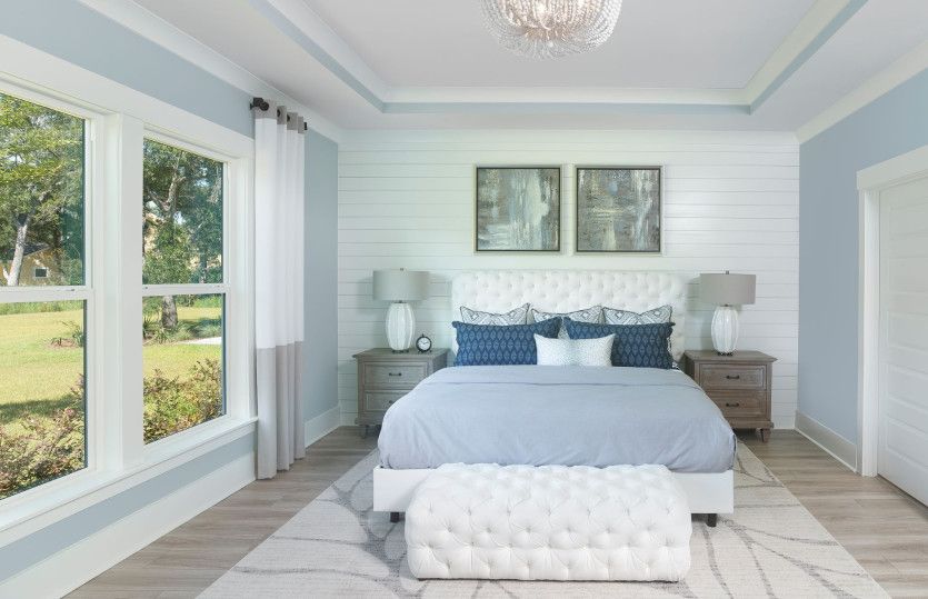 The natural sunlight from the large windows fills the spacious owner's suite, creating a peaceful at