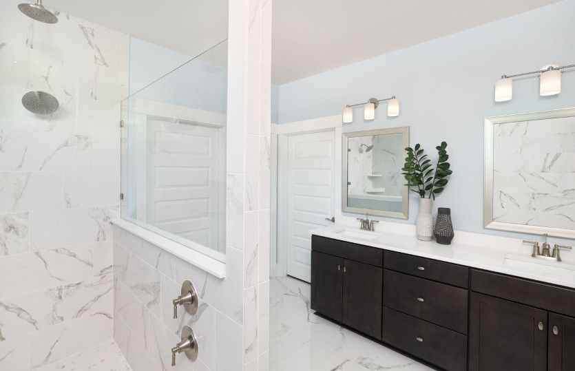 Owner's bath is equipped with large cabinets and a luxurious walk-in shower.