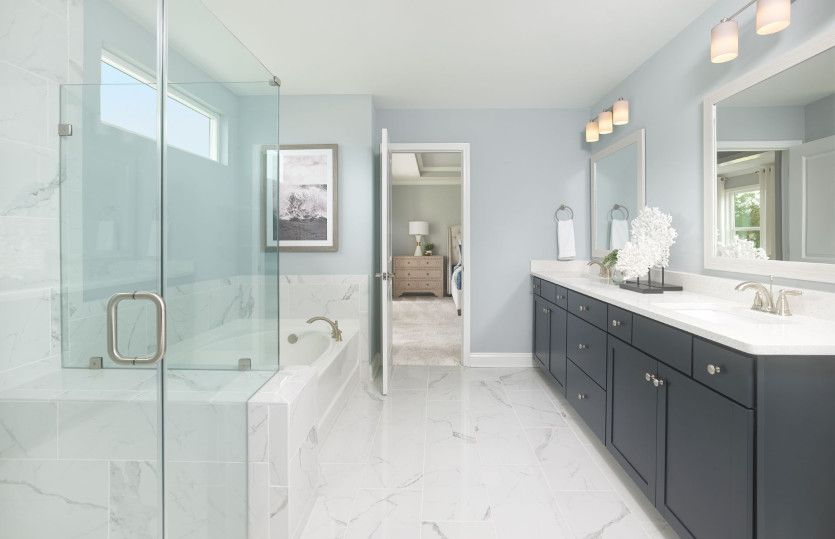 The beautiful owner's bath is equipped with rustic white framed mirrors and a walk-in shower.