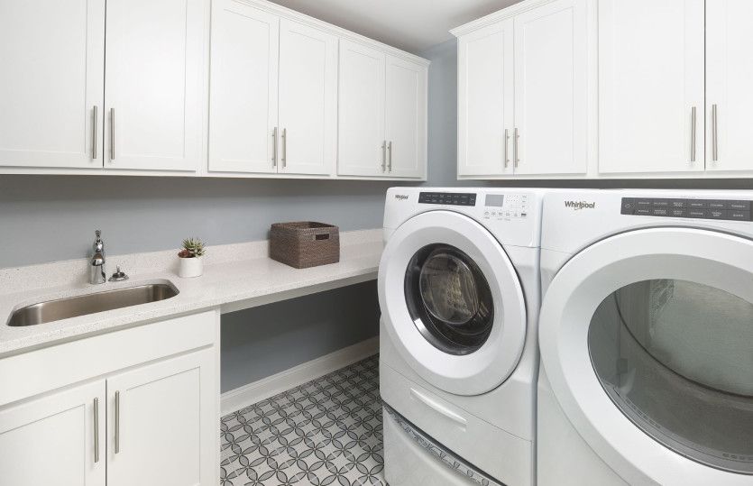The second-floor laundry room has bright white cabinets perfect for storage and an optional sink for