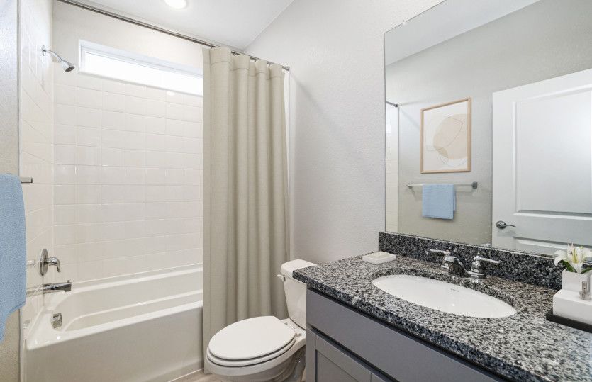 The secondary bathroom boasts a shower/tub combo and granite countertops.