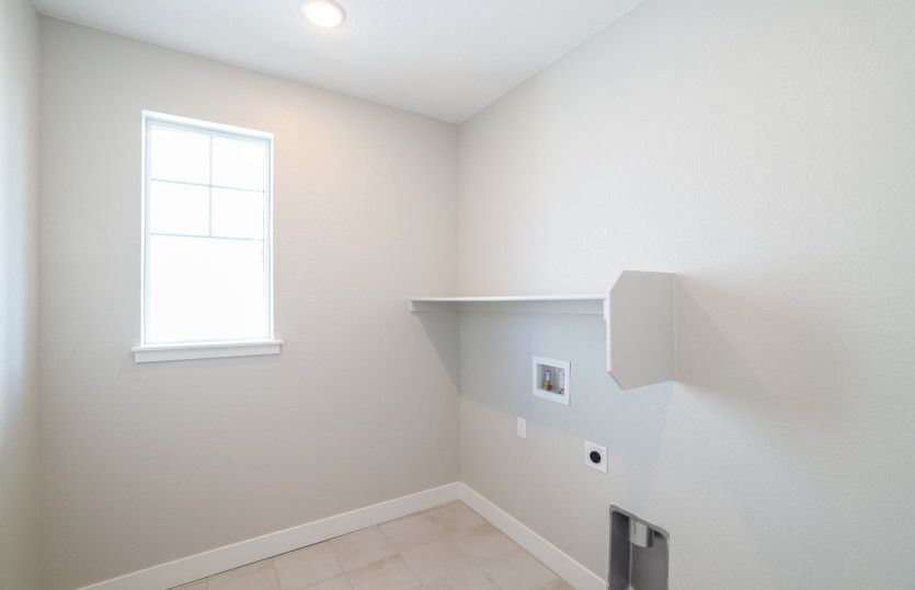 The Brownstone features a spacious laundry room with tile floors.