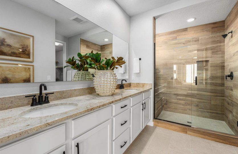Owner's bath in the Gateway shown with a double vanity and elegant walk-in shower.