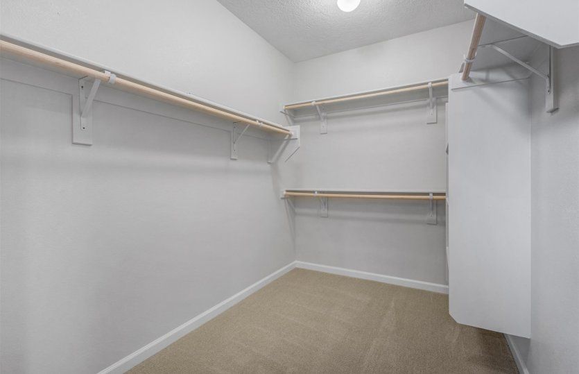 The walk-in closet is spacious and features plenty of built-in storage.