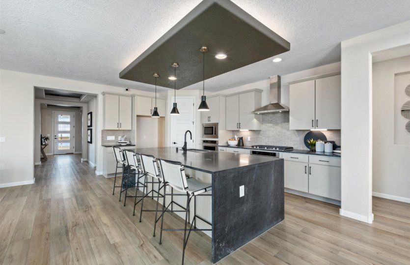 Staggered cabinets, designer pendant lights, and built-in stainles-steel appliances show off the Par