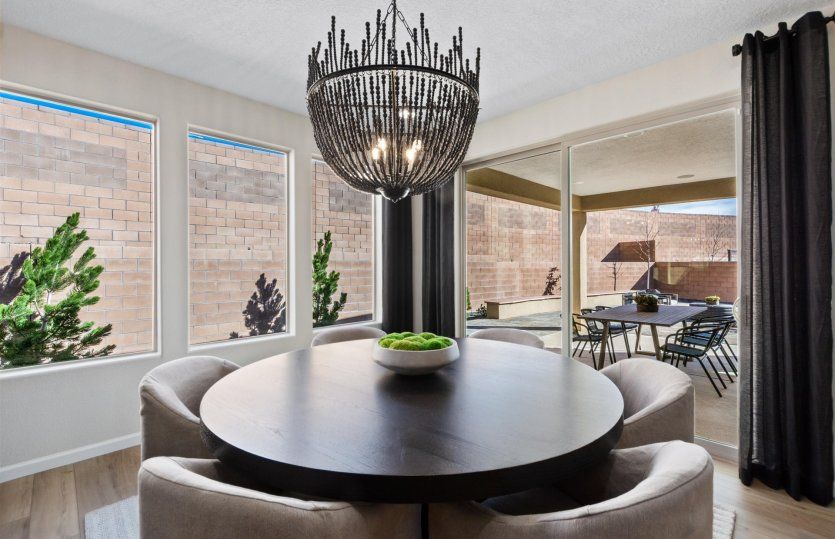Overhead accent lighting fixtures, large windows, and a sliding glass door accent provide modern bea