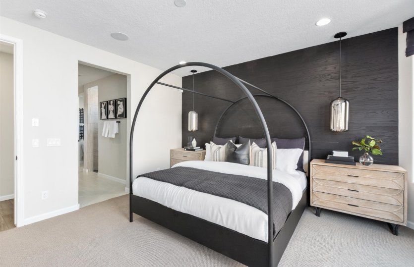 Large windows, an accent wall, and accent lighting fixtures amplify the spacious owner's suite.