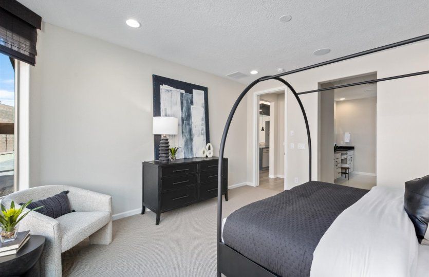 Owner's suite shown with a large bed and cozy accent chair.
