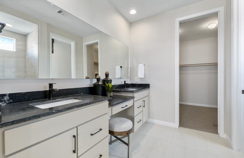 Dual vanity boasts a large mirror and ample cabinet space.