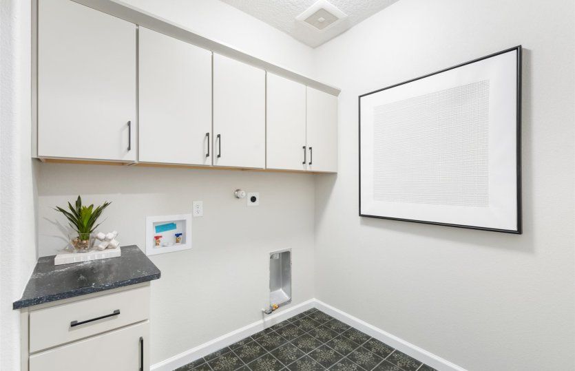 The laundry room boasts additional storage space.