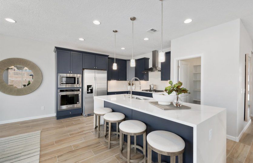 Open kitchen with breakfast bar seating at the waterfall kitchen island.