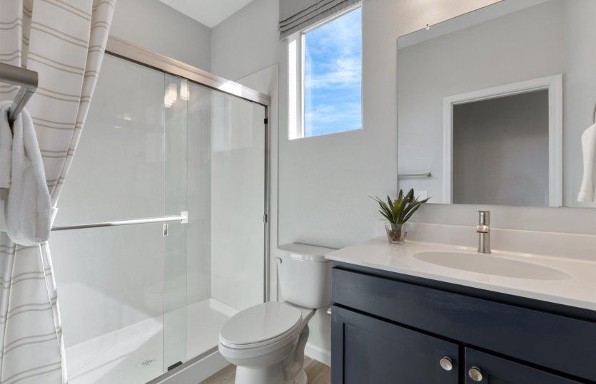 Suite bathroom includes a walk-in shower and beautiful white countertops.