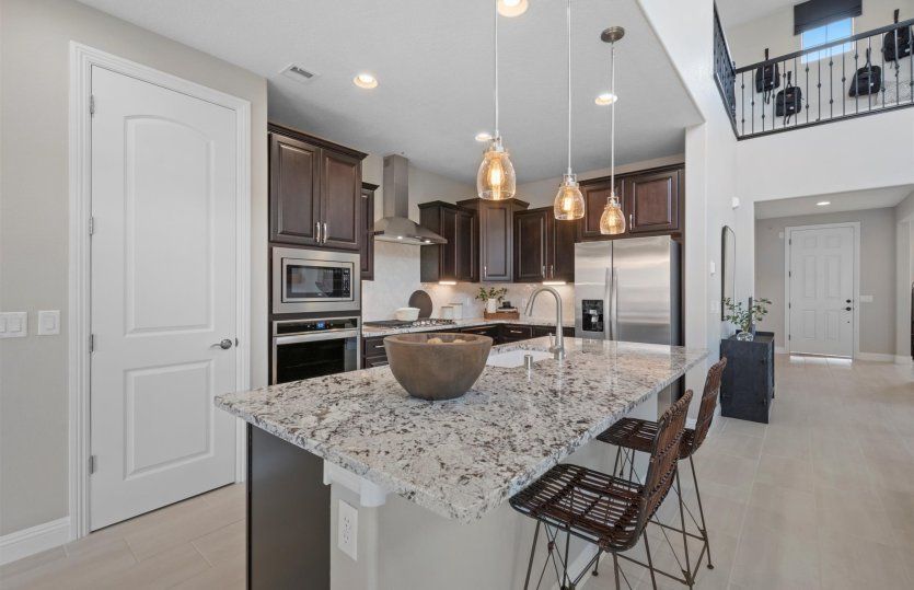 Kitchen include large island, stainless-steel appliances, and extended cabinetry.