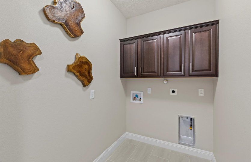 Laundry room with cabinets for additional storage.