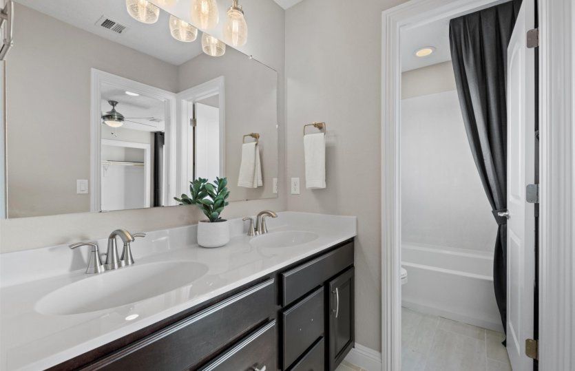 Bath with two sinks and a shower/tub combo located just outside upstairs bedrooms 2 and 3.