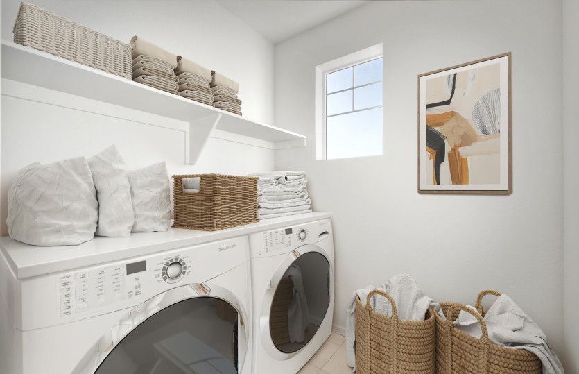 The upstairs laundry room boasts tile flooring and built-in shelving.