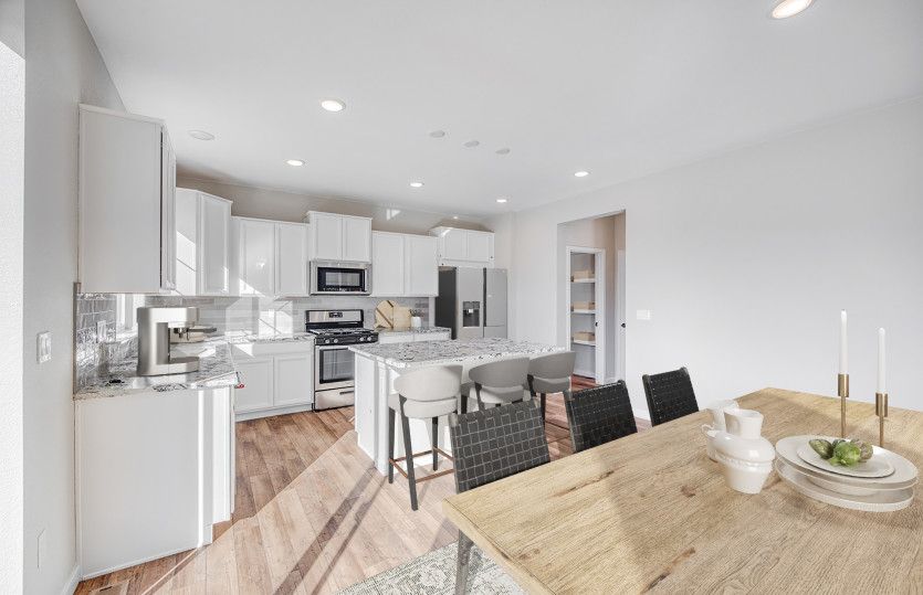 The kitchen connects to a spacious, walk-in pantry for added functionality.