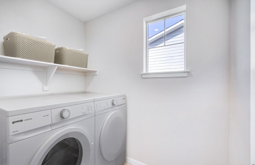 The upstairs laundry room is conveniently located and features built-in storage.