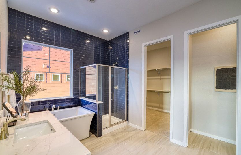 Enter the owner's bath which features a free standing tub, walk-in shower, and stunning tile accents