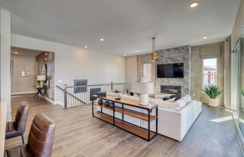 The spacious gathering room features a fireplace shown with stylish floor to ceiling tile accents.