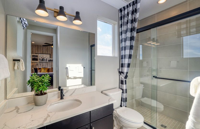 This bathroom is shown with upgraded pendant lighting and a walk-in shower.