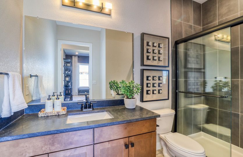 Enhance your secondary bathroom with vanity lighting and stylish tile accents.
