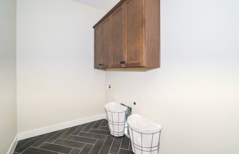 The laundry room can be enhanced with additional cabinets for convenience.