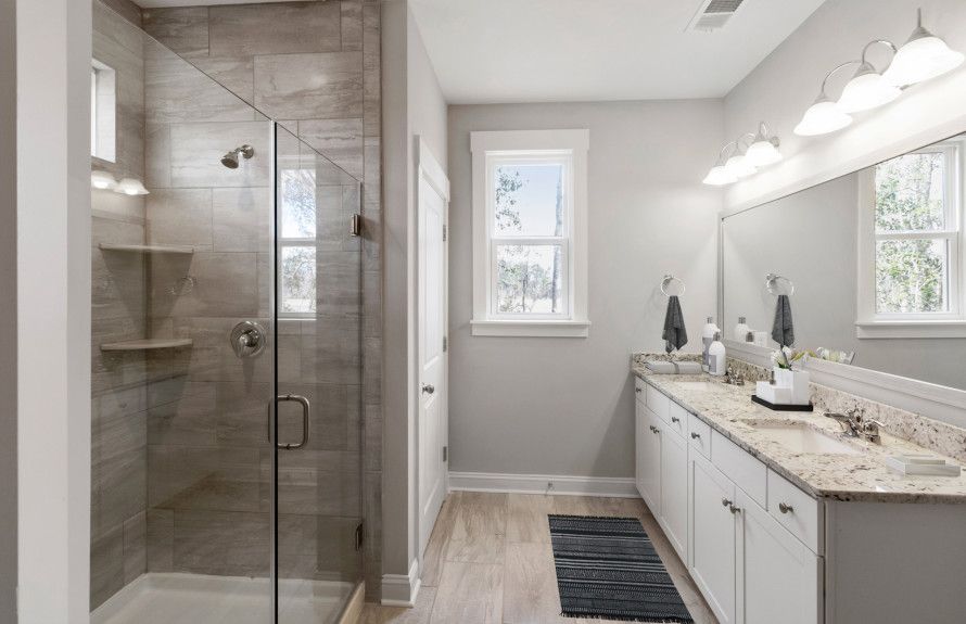Luxurious Owner's Bathroom with a dual-sink vanity and glass door shower