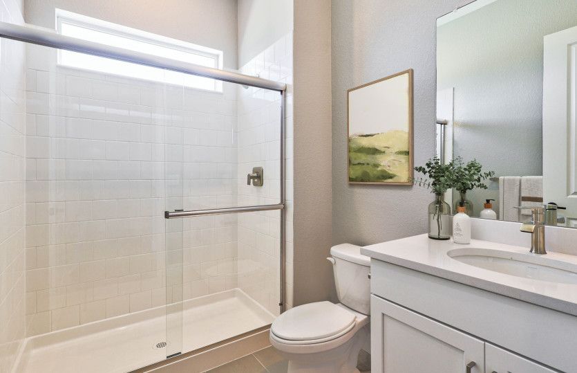 The secondary bathroom shown with a walk-in shower and granite countertops.