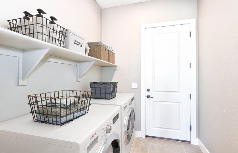 The laundry room features built-in shelving for added functionality.