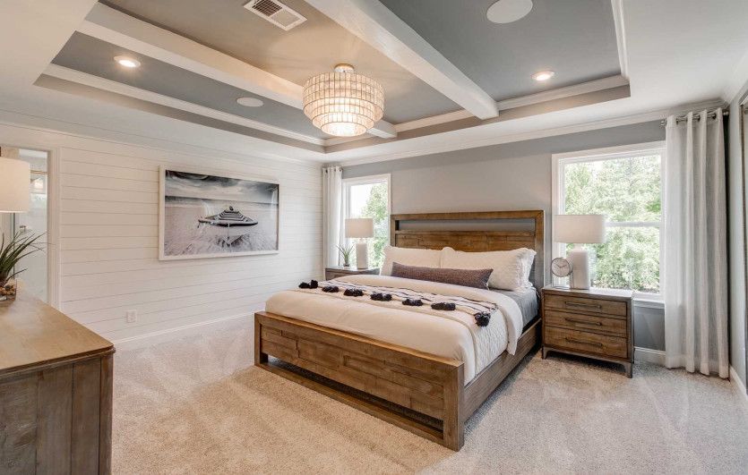 Elegant Owner's Suite with a tray ceiling, large windows allowing natural light to fill the room.