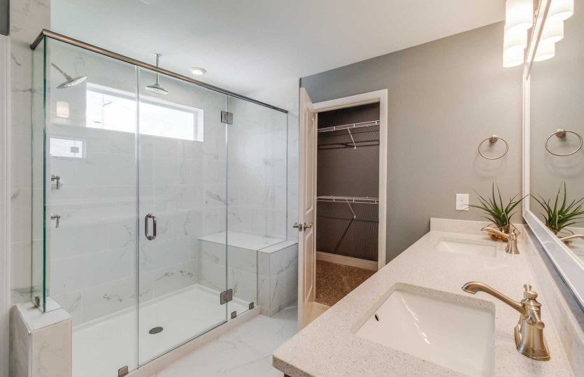 Owner's Bath with a walk-in shower equipped with a bench and rainfall shower head.
